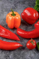 Red and yellow vegetables on the grey table.