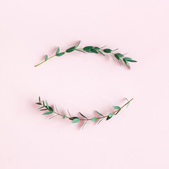 Flowers composition. Wreath made of eucalyptus leaves on pink background. Spring concept. Flat lay, top view, copy space, square