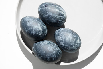 Naturally dyed blue eggs prepared for Easter on white background. Happy Easter card. Easter background with Easter eggs in a ceramic gray bowl. Background with easter eggs. Top view 