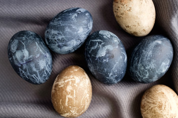 Background with easter eggs. Naturally dyed eggs prepared for Easter on gray texture tablecloth background. Happy Easter
