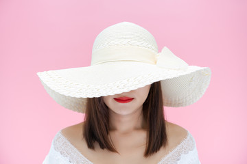 Girl with white sun hat smiling on red lipstick on pink background