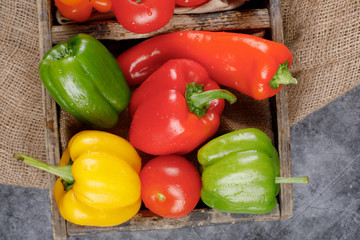 Color bell peppers in a rustic tray. Top view.