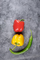 Artistic photo shooting of red, yellow bell pepper and a green chili. Top view.
