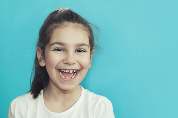 Portrait of happy laughing child girl on bright background. Smiling kid. Positive emotions.