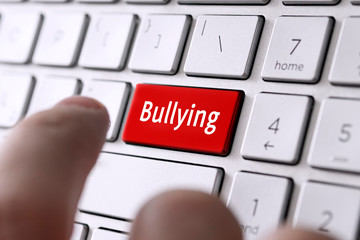word bullying on the computer's gray keyboard. The concept of harassment intimidation and...