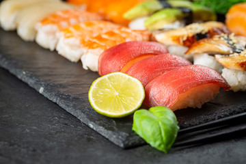 Set of sushi and maki with soy sauce over black background. Top view with copy space