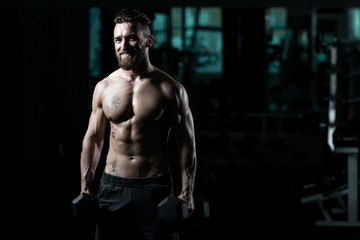 Plakat Bodybuilder Exercising Biceps With Dumbbells