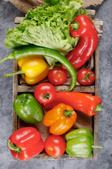 Colorful bell peppers and a bunch of lettuce. Top view.