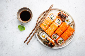 Set of sushi and maki with soy sauce over white background. Top view with copy space