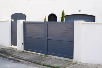 Fotobehang steel big grey metal gate fence on modern house street © OceanProd