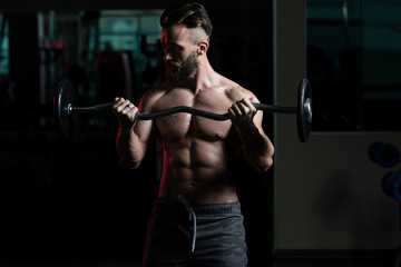Fototapeta na wymiar Athlete Working Out Biceps In A Gym