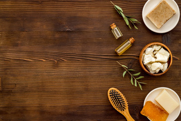 Hair care concept. Coconut oil, brush on dark wooden background top-down frame copy space