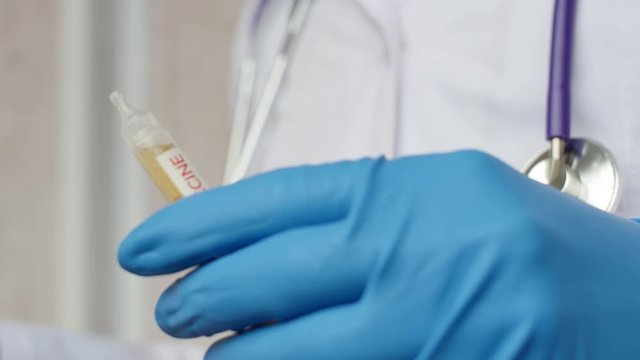 Medical doctor or laborant holding tube with nCoV Coronavirus vaccine for 2019-nCoV COVID virus. Novel Coronavirus originating in Wuhan, China. Coronavirus 2019-nCoV COVID concept.