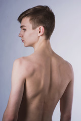 Naklejka premium Portrait of a young brown-haired man with a naked torso, a view from the back and a full-face portrait