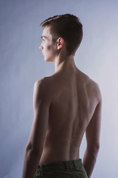 Portrait of a young brown-haired man with a naked torso, a view from the back and a full-face portrait