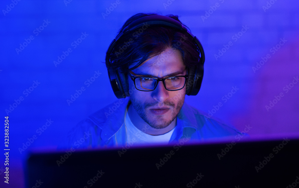 Aufkleber developer in eyeglasses working on desktop pc indoor at night
