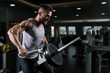 Fototapeta na wymiar Muscular Man Doing Heavy Weight Exercise for Back