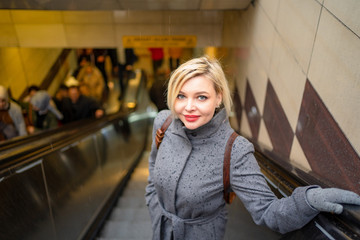 Beautiful blonde with short hair goes down to the subway after the rain