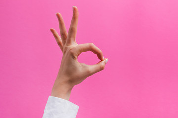 cropped shot of woman showing okay sign isolated on pink