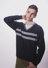 Fototapeta premium Lifestyle photo of a young brown-haired man on a light background, a beautiful young guy in a shirt and sweater