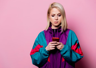Surprised mlonde woman in sport siut of 90s on pink background