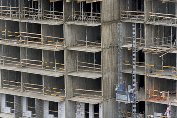 Fragment of under construction apartment building. The front of the house without walls