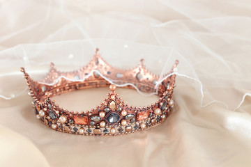 Vintage tiara over white delicate silk. Wedding concept. © tomertu