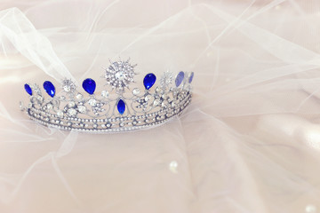 Vintage tiara over white delicate silk. Wedding concept. © tomertu