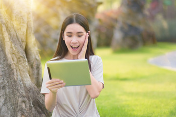 Fototapeta premium Woman use tablet sitting at city park happiness in day time online internet technology