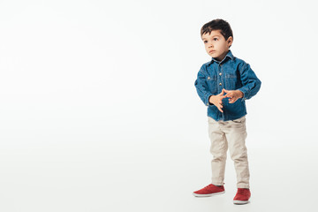 cute boy in denim shirt looking away on white background