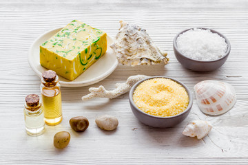 Spa set with mineral salt and oil on white wooden background