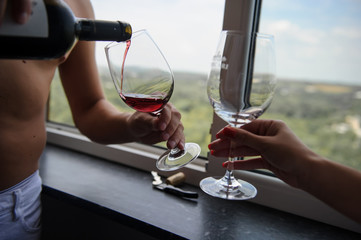 Close up photo hands of young couple pour wine