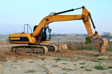 Fototapeta na wymiar Bucked tracked excavator digs ground at a construction site for installing concrete storm pipes. Backhoe the digging pipeline ditch. Commercial and Public Civil Work Contracting, trenching, tamps soil