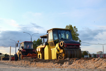 Road roller working at construction site during asphalt road repair. Paving roller machine on paving works.
