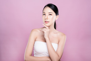 Asian woman poses for healthy skin beauty in pink seamless background. Cosmetic, skincare, surgery concept with copy space.