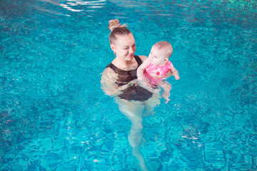 young mother teaches her child to swim