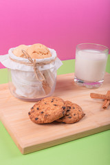 Cup of milk with jar of biscuits and cinnamon