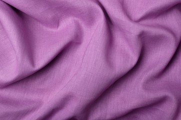 Top view of purple linen fabric with folds. Empty space for design