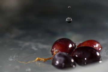 Bunches of grapes in ice water with colorful flashes photographed in studio