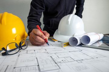 The architect is working to design the building at the office desk.