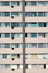 Old residential building facade with windows and air conditioners in Montreal, Canada.