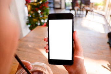 Mockup picture of business man’s hands holding smart phone with white blank screen in modern place.