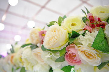 Lots of multicolored blooming roses. Beautiful flowers in bloom. Big bouquet of artificial roses. Flower background.