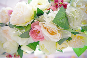 Lots of multicolored blooming roses. Beautiful flowers in bloom. Big bouquet of artificial roses. Flower background.