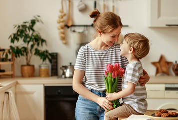 happy mother's day! child son gives flowers for  mother on holiday .