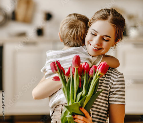 happy mother's day! child son gives flowers for  mother on holiday .