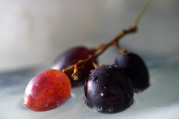 Bunches of grapes in ice water with colorful flashes photographed in studio