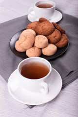 Cups of black tea with biscuits