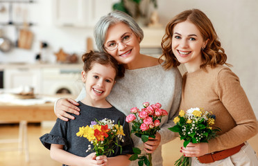 mother's day! three generations of  family mother, grandmother and daughter congratulate on the holiday, give flowers .