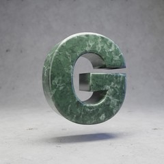 Green marble letter G uppercase on concrete background